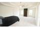 Spacious bedroom with a tray ceiling, ceiling fan, white carpet, and an armoire between two windows at 1851 Harvest Way, Loganville, GA 30052