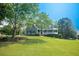 Beautiful two-story house featuring a lush green lawn and mature trees on a sunny day at 1851 Harvest Way, Loganville, GA 30052