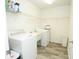Well-lit laundry room with modern washer, dryer, utility sink, and ample shelving for storage at 1851 Harvest Way, Loganville, GA 30052