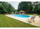 The backyard features an in-ground pool, lounge furniture, and cabana at 1851 Harvest Way, Loganville, GA 30052