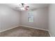 Bedroom features neutral paint, carpet, ceiling fan and window at 604 Hamlet Se Ct, Conyers, GA 30094