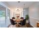 Cozy dining area with a stylish chandelier, a round wooden table and backyard access at 604 Hamlet Se Ct, Conyers, GA 30094