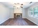 Spacious living room with wood-look floors, a ceiling fan, and a classic brick fireplace at 604 Hamlet Se Ct, Conyers, GA 30094