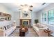 Inviting living room with a brick fireplace, ceiling fan, and large window offering natural light at 604 Hamlet Se Ct, Conyers, GA 30094
