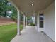 Covered back porch area featuring sturdy support beams and a serene view of the fenced backyard at 6135 Stillwood Ln, Cumming, GA 30041