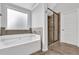 The bathroom features a separate tub, glass enclosed shower, and neutral tile work at 6135 Stillwood Ln, Cumming, GA 30041