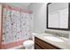 Cozy bathroom featuring floral shower curtain and a wood vanity with granite countertop at 6135 Stillwood Ln, Cumming, GA 30041