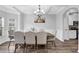 Elegant dining room with tray ceiling, hardwood floors, and modern chandelier at 6135 Stillwood Ln, Cumming, GA 30041
