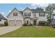 Beautiful two-story home with a manicured lawn, complemented by a two-car garage at 6135 Stillwood Ln, Cumming, GA 30041
