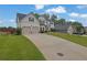 Inviting two-story home with a spacious driveway and a two-car garage, set against a lush green lawn at 6135 Stillwood Ln, Cumming, GA 30041