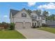 Lovely two-story home with a two-car garage and a spacious driveway, surrounded by green landscaping at 6135 Stillwood Ln, Cumming, GA 30041
