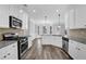Modern kitchen with stainless steel appliances and white cabinets overlooking breakfast area at 6135 Stillwood Ln, Cumming, GA 30041