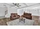 Open-concept living area featuring hardwood floors, coffered ceilings, and comfortable leather furniture at 6135 Stillwood Ln, Cumming, GA 30041