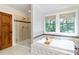 Bathroom boasts a soaking tub, glass shower, and natural light at 1268 Harris Road Rd, Lawrenceville, GA 30043