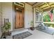Inviting covered front porch with a wooden door, seating area, and an American flag at 1268 Harris Road Rd, Lawrenceville, GA 30043