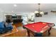 Billiards room boasts hardwood floors, a red pool table, and a custom light fixture at 1268 Harris Road Rd, Lawrenceville, GA 30043