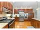 Traditional kitchen features wood cabinets, stainless steel appliances, granite countertops and hardwood floors at 1268 Harris Road Rd, Lawrenceville, GA 30043