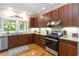 Traditional kitchen features wood cabinets, stainless steel appliances, granite countertops and hardwood floors at 1268 Harris Road Rd, Lawrenceville, GA 30043