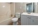 Cozy bathroom with a vanity, toilet, and tub-shower combination with white tile surround at 1410 Willow Dr, Riverdale, GA 30296