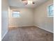 A room with a carpeted floor, a ceiling fan, and windows that let in natural light at 1410 Willow Dr, Riverdale, GA 30296