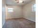 A room with a carpeted floor, a ceiling fan, and windows that let in natural light at 1410 Willow Dr, Riverdale, GA 30296