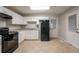 Functional kitchen equipped with white cabinets, appliances, and a door that provides backyard access at 1410 Willow Dr, Riverdale, GA 30296