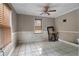 Neutral bedroom with tiled floors, a window, and a ceiling fan; needs work at 1550 Bells Ferry Rd, Marietta, GA 30066