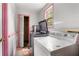 Functional laundry room with pink trim, washer, dryer, storage shelves, and tile floors at 1550 Bells Ferry Rd, Marietta, GA 30066