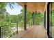 Spacious back porch with overhead fan, wooden floors, and black metal railing overlooks a wooded lot at 3117 Robinson Ave, Scottdale, GA 30079