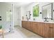 Modern bathroom featuring wood cabinets, dual vanities, black fixtures, and a walk-in shower at 3117 Robinson Ave, Scottdale, GA 30079