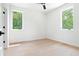 Clean bedroom featuring two windows offering bright light, hardwood floors, and a neutral color palette at 3117 Robinson Ave, Scottdale, GA 30079