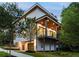Home featuring an open balcony, wood accents, and a scenic wooded backdrop at 3117 Robinson Ave, Scottdale, GA 30079