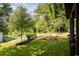 Well-manicured front yard featuring lush green grass, attractive landscaping, and mature trees at 3117 Robinson Ave, Scottdale, GA 30079