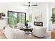 Spacious and naturally lit living room with modern fireplace and view of the wooded landscape from the large windows at 3117 Robinson Ave, Scottdale, GA 30079