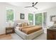 Main bedroom with views to the wooded back yard and featuring neutral earth tone decor and ceiling fan at 3117 Robinson Ave, Scottdale, GA 30079