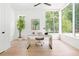 Bright home office featuring hardwood floors, a modern desk, and large windows with a view of lush greenery at 3117 Robinson Ave, Scottdale, GA 30079