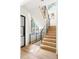 Bright entryway featuring a modern staircase with wood steps and metal railings at 3117 Robinson Ave, Scottdale, GA 30079