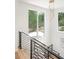 Staircase features modern metal railings, wood steps, and scenic backyard views through large windows at 3117 Robinson Ave, Scottdale, GA 30079