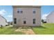View of backyard with grass leading up to two-story home with neutral siding and several windows at 7099 Skippingstone Way, Douglasville, GA 30134