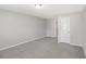 Neutral bedroom showing light gray walls, light carpeting, and a doorway to another room at 7099 Skippingstone Way, Douglasville, GA 30134