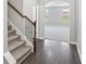 Home entrance featuring a staircase with decorative banister, and dark wood flooring, leading to an open doorway at 7099 Skippingstone Way, Douglasville, GA 30134