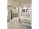Bright bathroom with separate tub and shower, tile floor and gray accent walls at 776 Woodstock Grove Dr, Woodstock, GA 30188