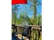 Secluded deck featuring a view of the surrounding trees, and comfortable seating, under a shaded awning at 776 Woodstock Grove Dr, Woodstock, GA 30188