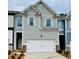 Charming townhome featuring a two-car garage and neutral siding with decorative shutters at 776 Woodstock Grove Dr, Woodstock, GA 30188