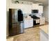 Spacious kitchen with stainless steel fridge, granite counters, and white cabinetry at 776 Woodstock Grove Dr, Woodstock, GA 30188