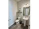 Half bathroom with pedestal sink, toilet, and decorative mirror at 776 Woodstock Grove Dr, Woodstock, GA 30188