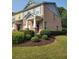 Brick townhome with manicured landscaping, lush green grass, and mature trees in a well-kept community at 803 Arbor Gate Ln, Lawrenceville, GA 30044