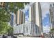 Modern high-rise building featuring glass facade and urban landscaping with tree line at 1280 W Peachtree Nw St # 3514, Atlanta, GA 30309