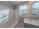 Bathroom with tub and shower combination and white vanity with bright, natural light at 1453 Graham Sw St, Atlanta, GA 30310