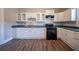 Updated kitchen with white cabinetry, modern appliances, and laminate floors at 1453 Graham Sw St, Atlanta, GA 30310